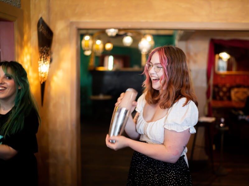 Woman making cocktails at a class experience she redeemed for Mother's Day